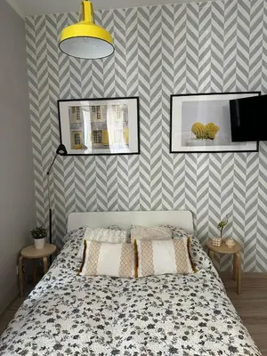 a bedroom with a bed and a striped wall at Apartament Mazowiecka 11 in Kraków