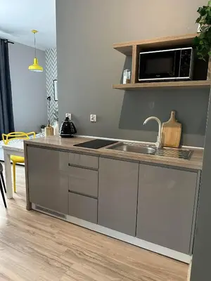 a kitchen with a sink and a microwave at Apartament Mazowiecka 11 in Kraków