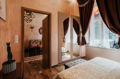 a bedroom with a bed and a large mirror at Apartament Shahrazad in Kraków