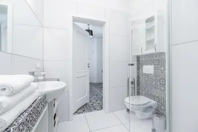 a white bathroom with a toilet and a sink at Two Bedroom Apartment- Brzozowa - Kazimierz in Kraków