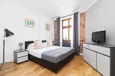 a bedroom with a bed and a tv in it at Two Bedroom Apartment- Brzozowa - Kazimierz in Kraków
