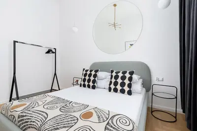 a bedroom with a bed and a clock on the wall at Old Town - Modern Apartment - 7 Gertrudy street in Kraków