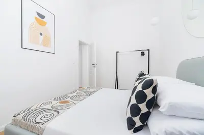 a white bedroom with a bed and a chair at Old Town - Modern Apartment - 7 Gertrudy street in Kraków