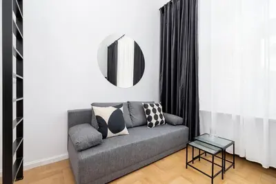 a living room with a gray couch and a mirror at Old Town - Modern Apartment - 7 Gertrudy street in Kraków