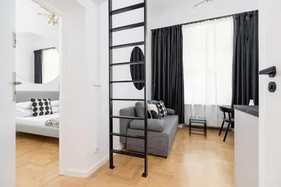a living room with a black ladder next to a bedroom at Old Town - Modern Apartment - 7 Gertrudy street in Kraków