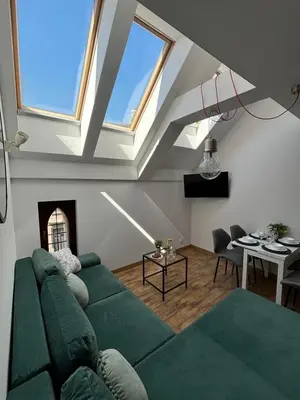 a living room with a green couch and a table at Moonlight Apartment Cracow in Kraków