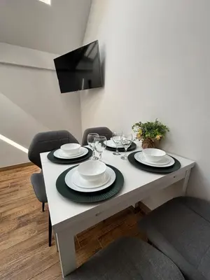 a dining room table with plates and wine glasses at Moonlight Apartment Cracow in Kraków