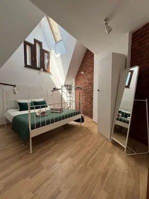 a bedroom with a green bed and a brick wall at Moonlight Apartment Cracow in Kraków