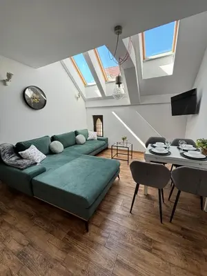 a living room with a green couch and a table at Moonlight Apartment Cracow in Kraków