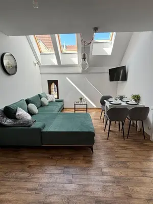 a living room with a green couch and a table at Moonlight Apartment Cracow in Kraków