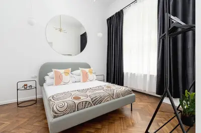 a bedroom with a bed with pink pillows and a mirror at Wawel Castle - Modern Apartment - 7 Gertrudy in Kraków