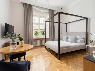 a bedroom with a canopy bed and a table at Main Square - Szpitalna 9 Street in Kraków