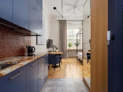 a kitchen with blue cabinets and a dining room at Main Square - Szpitalna 9 Street in Kraków