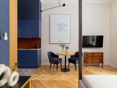 a kitchen with blue cabinets and a table and chairs at Main Square - Szpitalna 9 Street in Kraków