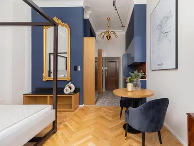 a bedroom with a bed and a table and a mirror at Main Square - Szpitalna 9 Street in Kraków