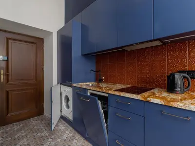a kitchen with blue cabinets and a washing machine at Main Square - Szpitalna 9 Street in Kraków