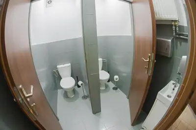 a bathroom with two toilets and a mirror at Hostel Graffiti in Kraków