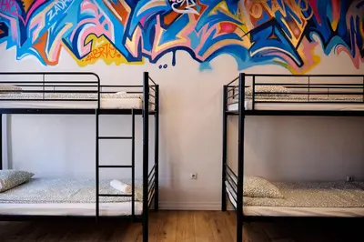 two bunk beds in a room with a graffiti wall at Hostel Graffiti in Kraków