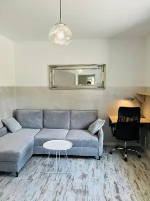 a living room with a couch and a table at Apartament ogrodowy in Miechów