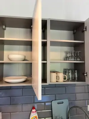 a kitchen cabinet with plates and utensils in it at Apartament ogrodowy in Miechów
