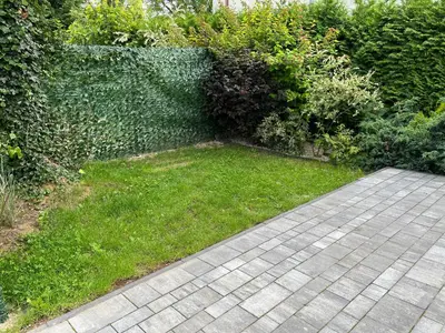 a garden with a brick walkway and green grass at Apartament ogrodowy in Miechów