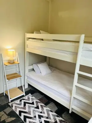 two bunk beds in a room with a lamp and a table at Apartament ogrodowy in Miechów