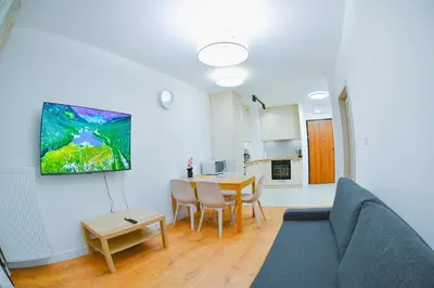 a living room with a blue couch and a table at Elegant Two-Room Apartment, Sleeps 4, Near Turon Arena, Balcony ,Air condition in Kraków