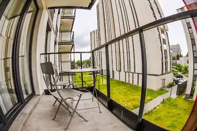a balcony with a table and chairs on a building at Elegant Two-Room Apartment, Sleeps 4, Near Turon Arena, Balcony ,Air condition in Kraków