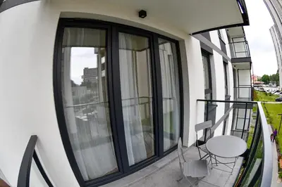 a balcony with a table and a chair on a building at Elegant Two-Room Apartment, Sleeps 4, Near Turon Arena, Balcony ,Air condition in Kraków