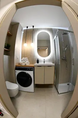a bathroom with a sink and a washing machine at Elegant Two-Room Apartment, Sleeps 4, Near Turon Arena, Balcony ,Air condition in Kraków