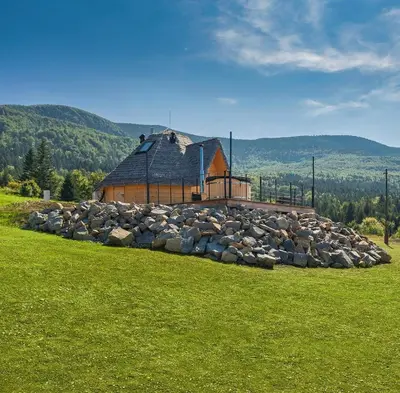 a large pile of rocks in front of a building at Osada Poli Zawoja - Panoramiczny Domek z Prywatną Balią i Hydromasażem in Skawica