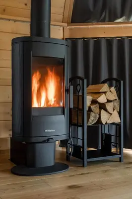 a stove in a room with a fire in it at Osada Poli Zawoja - Panoramiczny Domek z Prywatną Balią i Hydromasażem in Skawica