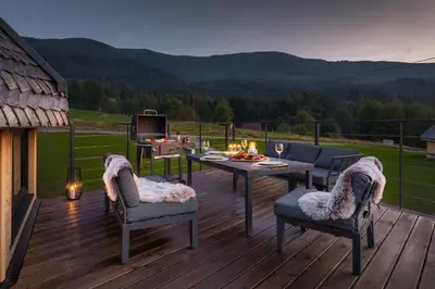 a deck with a table and chairs and a grill at Osada Poli Zawoja - Panoramiczny Domek z Prywatną Balią i Hydromasażem in Skawica