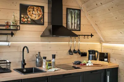 a kitchen in a log cabin with a sink and a stove at Osada Poli Zawoja - Panoramiczny Domek z Prywatną Balią i Hydromasażem in Skawica