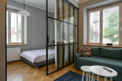 a living room with a green couch and a bed at Krowoderska Apartament in Kraków