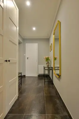a hallway with a door and a mirror at Krowoderska Apartament in Kraków