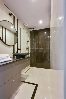 a bathroom with a glass shower and a sink at Krowoderska Apartament in Kraków