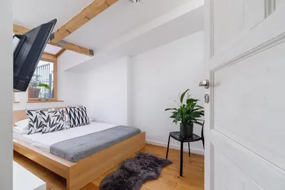 a room with a bed and a tv and a door at 2 bedroom Apartment with terrace- Piłsudskiego 11 in Kraków