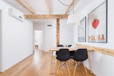 a dining room with a wooden table and black chairs at 2 bedroom Apartment with terrace- Piłsudskiego 11 in Kraków