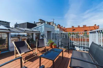 a balcony with three chairs on a roof at 2 bedroom Apartment with terrace- Piłsudskiego 11 in Kraków