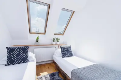 a room with two beds and two windows at 2 bedroom Apartment with terrace- Piłsudskiego 11 in Kraków