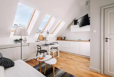 a white apartment with a kitchen and a living room at 1 - bedroom Apartment - 11 Pilsudskiego Street in Kraków