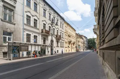 an empty street in a city with buildings at 1 - bedroom Apartment - 11 Pilsudskiego Street in Kraków