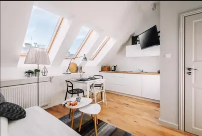 a white apartment with a kitchen and a living room at 1 - bedroom Apartment - 11 Pilsudskiego Street in Kraków