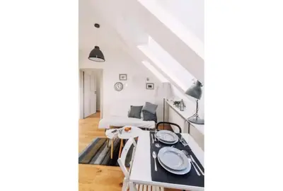 a white kitchen with a table in a room at 1 - bedroom Apartment - 11 Pilsudskiego Street in Kraków