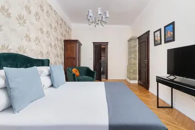 a bedroom with a large bed and a flat screen tv at Main square - Old Town - Floriańska 47 Street in Kraków