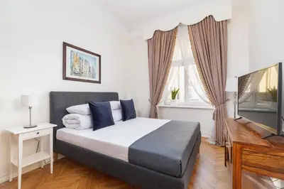 a bedroom with a bed and a flat screen tv at Main square - Old Town - Floriańska 47 Street in Kraków