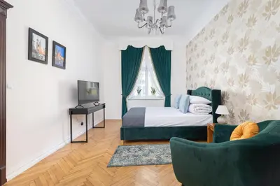a bedroom with a bed and a couch and a television at Main square - Old Town - Floriańska 47 Street in Kraków