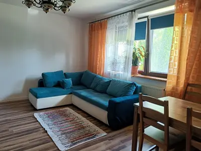 a living room with a blue couch in front of a window at Dom pod Krakowem - zacisze wsi 20 minut samochodem od centrum Krakowa in Pekowice