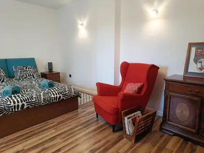 a bedroom with a red chair and a bed at Dom pod Krakowem - zacisze wsi 20 minut samochodem od centrum Krakowa in Pekowice